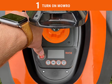 User showing how to power on the mowro mower
